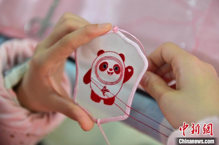 圖為一名小學(xué)生正在繡制2022年北京冬奧會吉祥物“冰墩墩”形象。　喻云亮 攝