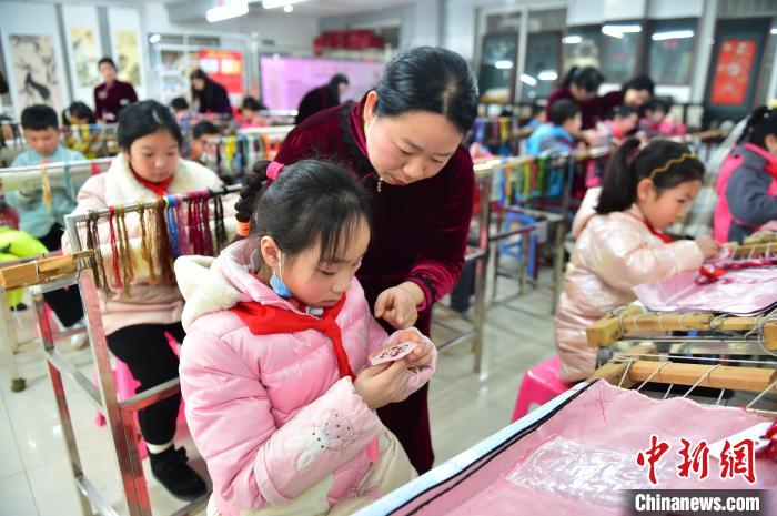 江西省級非遺豫章繡傳承人手把手指導(dǎo)小學(xué)生繡制2022年北京冬奧會吉祥物“冰墩墩”形象?！∮髟屏?攝