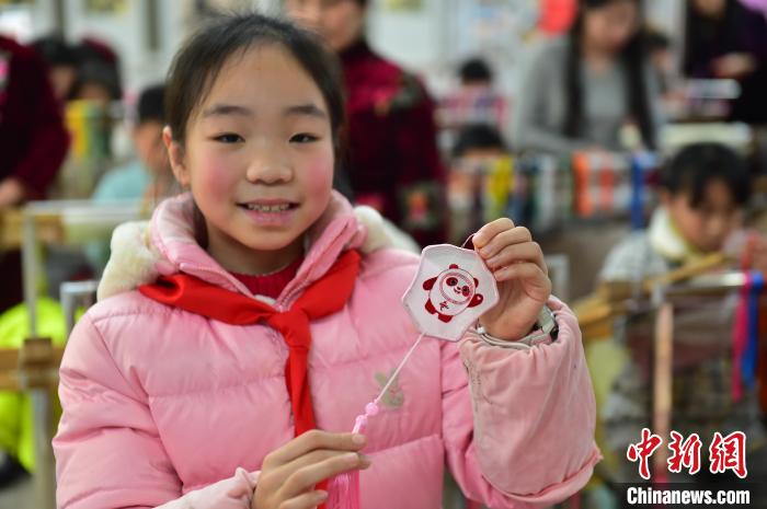 圖為一名小學(xué)生繡制的2022年北京冬奧會吉祥物“冰墩墩”形象?！∮髟屏?攝