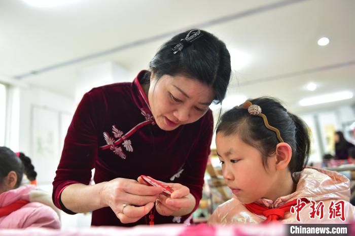 江西省級非遺豫章繡傳承人手把手指導(dǎo)小學(xué)生繡制2022年北京冬奧會吉祥物“冰墩墩”形象?！∮髟屏?攝