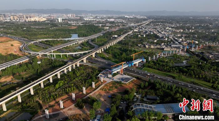 航拍正在建設(shè)的跨越成都繞城高速公路連續(xù)梁施工現(xiàn)場(chǎng)，旁邊依次為已運(yùn)營(yíng)的成渝高速鐵路和機(jī)場(chǎng)高速公路?！⒅铱?攝