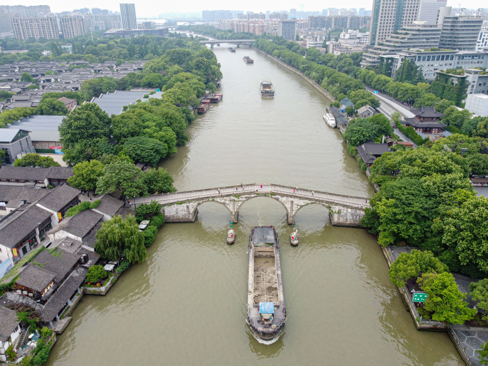 5月27日，一艘貨船駛過京杭大運河南端標志建筑杭州拱宸橋。(無人機照片)新華社記者江漢 攝
