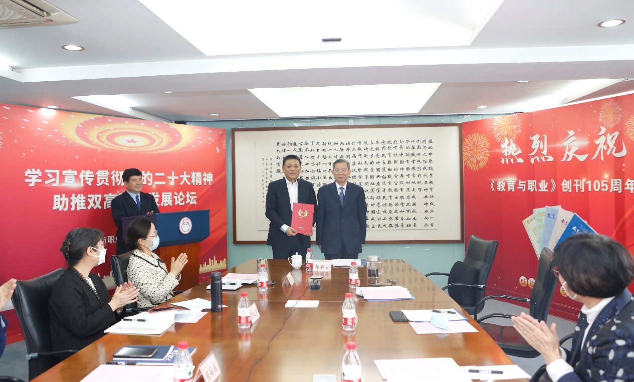 郝明金為《教育與職業(yè)》雜志編委代表陳曉明頒發(fā)聘書。中華職教社供圖