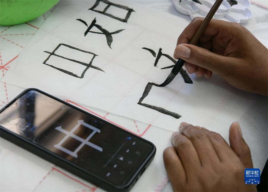 4月18日，肯尼亞學(xué)生在內(nèi)羅畢大學(xué)孔子學(xué)院舉辦的活動(dòng)上寫(xiě)毛筆字。肯尼亞內(nèi)羅畢大學(xué)孔子學(xué)院18日舉辦“中文，增進(jìn)文明對(duì)話”主題活動(dòng)，慶祝即將到來(lái)的第14個(gè)聯(lián)合國(guó)中文日?？夏醽唽W(xué)生參與互動(dòng)，進(jìn)行書(shū)法、剪紙、唱中文歌等活動(dòng)。新華社記者 韓旭 攝