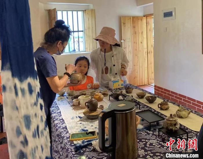 圖為：游客正在咨詢臺灣柴燒作品?！∪~秋云 攝