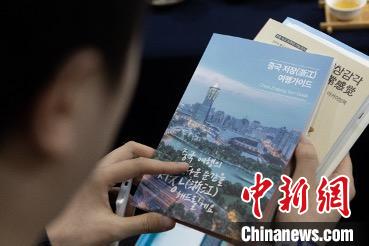 參展觀眾閱讀浙江文旅手冊?！《≌裾?攝