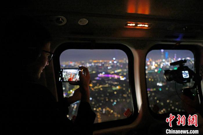 6月3日晚，游客乘坐上海新空直升機(jī)有限公司直升機(jī)開啟鳥瞰黃浦江空中圓夢(mèng)之旅，并用手機(jī)拍攝城市夜景?！∫罅⑶?攝
