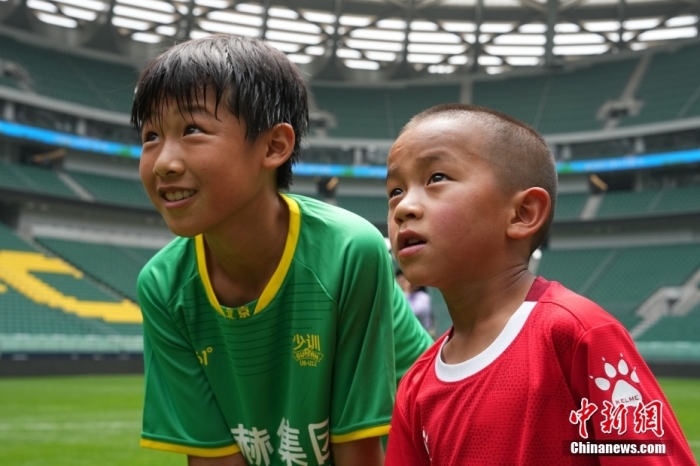 圖為北京國安小球員陳小北和7歲的俄金仁增在一起觀看場內(nèi)播放的紀錄片。<a target='_blank' href='/' _fcksavedurl='/'><p  align=