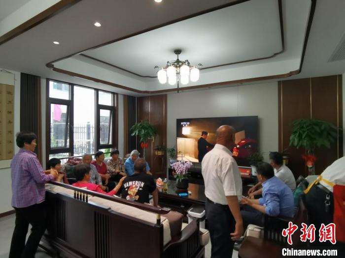 親友們集中在費(fèi)俊龍家中觀看返程的視頻?！＄娚?攝
