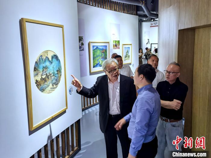 海峽兩岸藝術(shù)家畫展上，藝術(shù)家進(jìn)行藝術(shù)交流?！「毒窜?攝