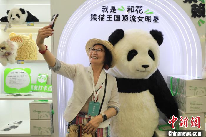 美國華視總裁楊蓮花與大熊貓文創(chuàng)產(chǎn)品合影?！⊥趵?攝
