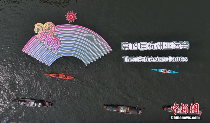 資料圖為烏篷船和皮劃艇從杭州亞運會標識前劃過。王剛 攝