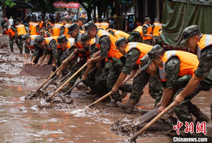 7月4日，萬(wàn)州區(qū)五橋街道，武警官兵清理街道上的淤泥?！∪矫宪?攝