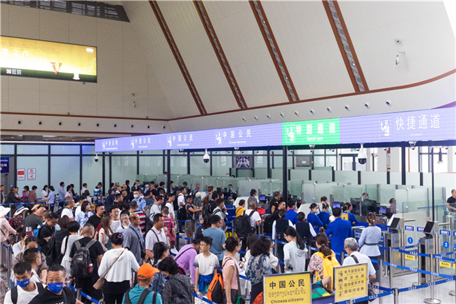 7月22日，乘坐中老鐵路國(guó)際旅客列車的旅客在磨憨邊檢大廳排隊(duì)候檢。衛(wèi)海林 攝