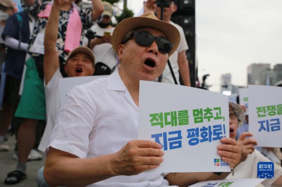 7月22日，在韓國(guó)首爾，人們手舉標(biāo)語(yǔ)參與反戰(zhàn)游行。新華社發(fā)（楊暢 攝）