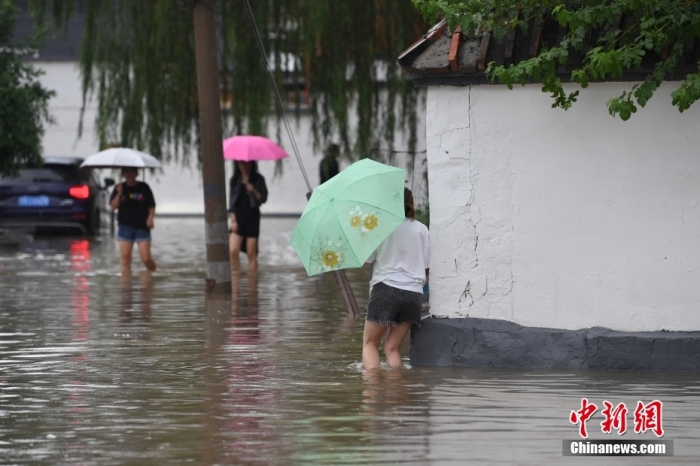7月31日，市民行走在雨中的北京房山區(qū)瓦窯頭村。北京市氣象臺當日10時發(fā)布分區(qū)域暴雨紅色預警信號。北京市水文總站發(fā)布洪水紅色預警，預計當日12時至14時，房山區(qū)大石河流域將出現(xiàn)紅色預警標準洪水。<a target='_blank' href='/'><p  align=