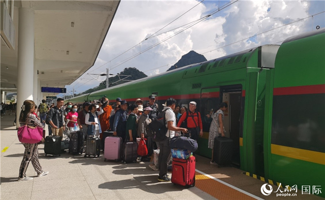 乘坐中老鐵路國際旅客列車的旅客在老撾瑯勃拉邦站排隊上車。人民網(wǎng)記者 杜明明攝