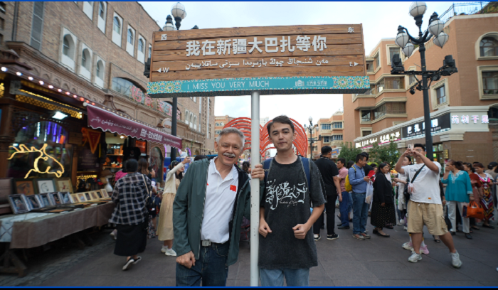 潘維廉和維吾爾族青年伊木蘭“打卡”大巴扎。主辦方供圖