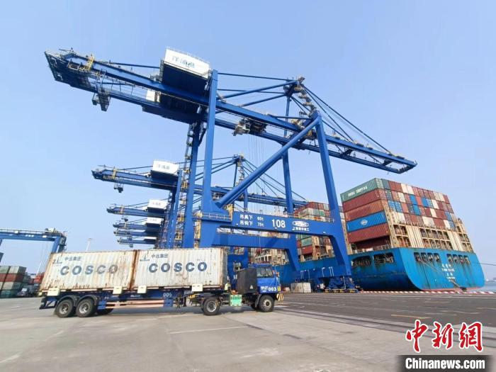 圖為海南洋浦國(guó)際集裝箱碼頭，卡車將集裝箱從后方堆場(chǎng)運(yùn)往碼頭裝卸區(qū)。　張?jiān)潞?攝
