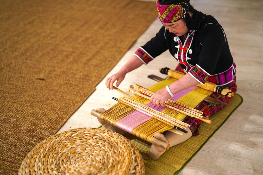 4月17日，黎族傳統(tǒng)紡染織繡技藝國家級代表性傳承人劉香蘭在2023年意大利米蘭設計周上展示黎錦織造技藝。新華社發(fā)