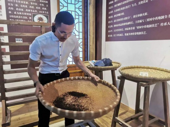 2023“一帶一路”媒體合作論壇聯(lián)合采訪團團員在非遺文化展示館體驗中藥炮制技藝。（本報記者 黃超攝）