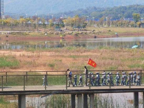　　10月24日，秋游的幼兒園小朋友在老師帶領(lǐng)下走在清水塘公園里的木橋上。本報(bào)記者 常雯宜攝