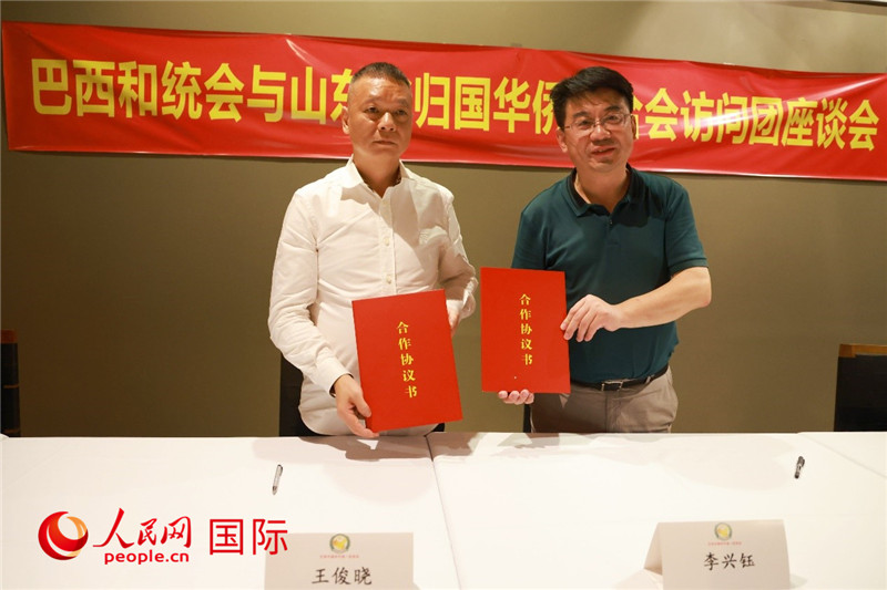 中國(guó)僑聯(lián)副主席、山東省僑聯(lián)主席李興鈺（右）與巴西和統(tǒng)會(huì)會(huì)長(zhǎng)王俊曉簽署合作協(xié)議書。人民網(wǎng)記者 陳海琪攝