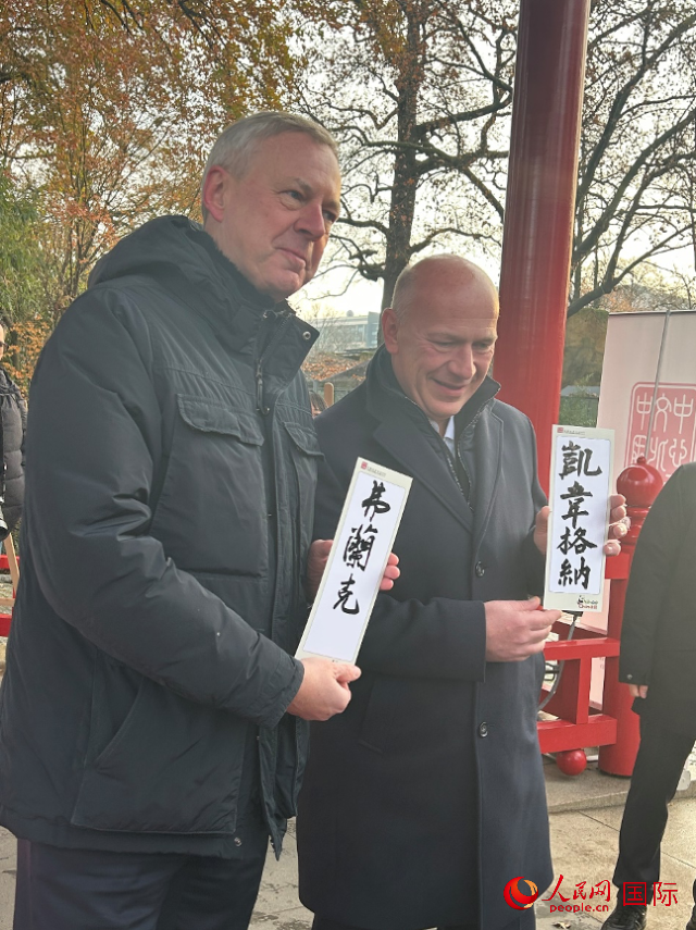 柏林市長韋格納（右）、動物園監(jiān)事會主席布魯克曼（左）手持中國文化中心工作人員現(xiàn)場手書的中文名字。人民網(wǎng)記者 徐馨攝