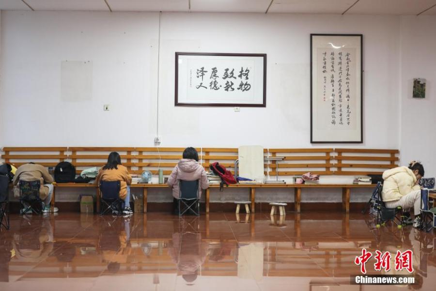 資料圖：幾位考研學(xué)生在南昌大學(xué)教學(xué)樓的公共空間復(fù)習(xí)備考。劉力鑫 攝