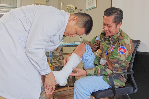 中國第22批赴黎維和醫(yī)療分隊軍醫(yī)為患者打石膏固定患肢。李清竹攝