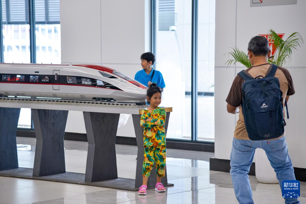 1月24日，在印度尼西亞雅加達(dá)哈利姆站候車大廳，一名小朋友和雅萬高鐵高速動車組模型合影。新華社記者 徐欽 攝