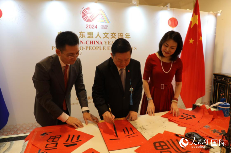 東盟秘書長高金洪（中）在活動現(xiàn)場寫福字。人民網(wǎng)記者曹師韻攝