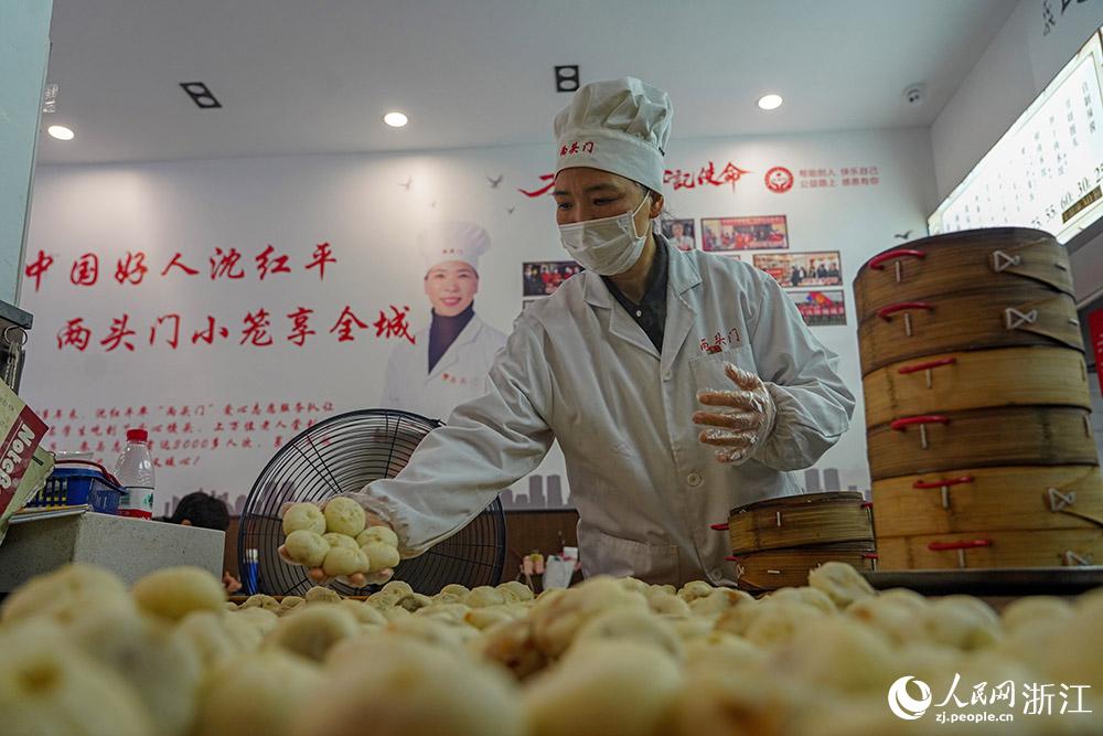 3月31日，在浙江省嵊州市甘霖鎮(zhèn)，嵊州小吃從業(yè)者沈紅平把蒸熟的小籠包晾涼，打包冷藏售賣。人民網(wǎng) 章勇濤攝