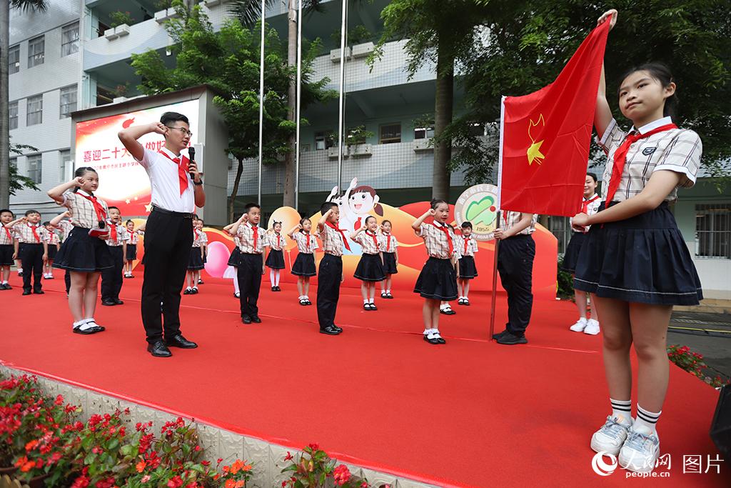 5月31日，在廣西壯族自治區(qū)南寧市民主路小學(xué)，學(xué)校大隊輔導(dǎo)員帶領(lǐng)少先隊員呼號。人民網(wǎng)記者 嚴(yán)立政攝