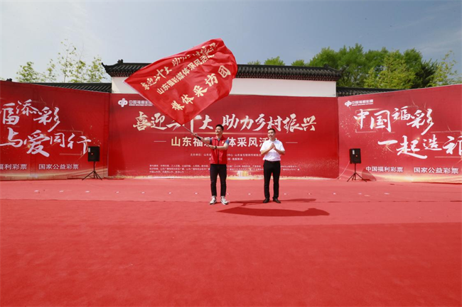 為媒體采風(fēng)團(tuán)授旗。 山東省福彩供圖
