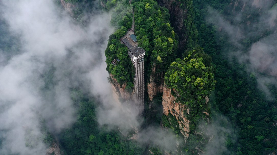 位于張家界武陵源景區(qū)的百龍?zhí)焯蓁偳对谠旗F繚繞的峰林間，雄偉壯觀。吳勇兵攝