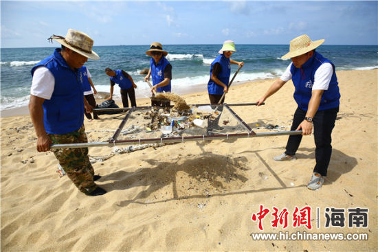 環(huán)保志愿者用篩網(wǎng)“淘”出海灘上的垃圾。