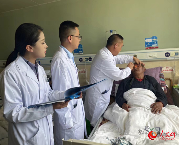 董光明（左三）帶領(lǐng)醫(yī)生對(duì)患者進(jìn)行術(shù)前檢查。人民網(wǎng)記者 杜燕飛攝