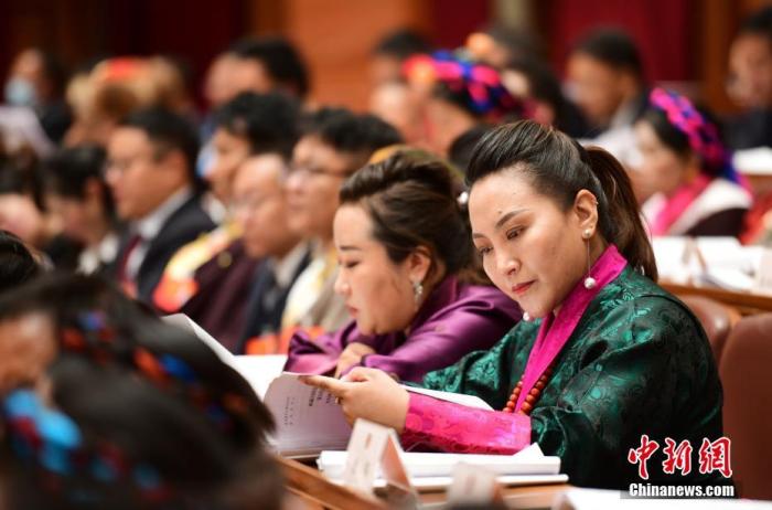 1月5日，次旦卓嘎(右一)在拉薩參加西藏自治區(qū)第十一屆人民代表大會第五次會議第二次全體會議。西藏自治區(qū)人大代表次旦卓嘎來自日喀則市定日縣，定日縣被稱為“洛諧故鄉(xiāng)”，作為西藏民間歌舞，洛諧已被列入中國國家非物質(zhì)文化遺產(chǎn)項目名錄，這是集歌、舞、樂、彈唱于一體的綜合藝術(shù)形式。參加完西藏2022年新年音樂會的次旦卓嘎告訴記者，每年參加的基層演出可達(dá)80場，“我希望用最純粹的方式，把最好的聲音帶到西藏乃至中國的各個角落。” <a target='_blank' href='/'><p  align=