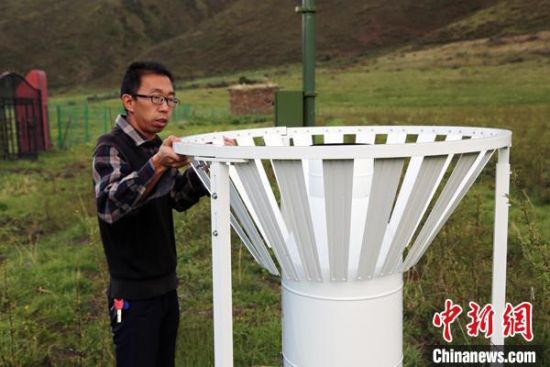 圖為班瑪縣氣象局工作人員在維護藏雪茶基地氣候站。青海省氣象局供圖