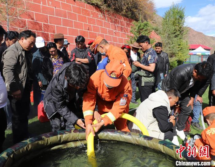 圖為森林消防員為護林員講解滅火裝備的使用方法。　昌都市森林消防支隊 供圖