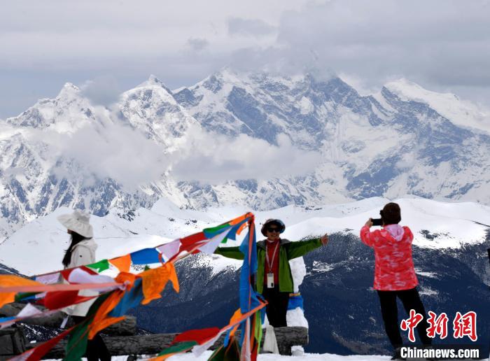 圖為5月14日，西藏林芝色季拉山觀景臺(tái)，游客與南迦巴瓦峰合影?！±盍?攝