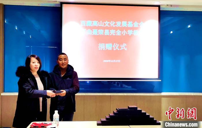 圖為西藏高山文化發(fā)展基金會理事長溫麗向聶榮縣完全小學(xué)負(fù)責(zé)人捐助儀器?！∮谫e 攝