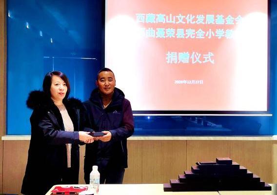 圖為西藏高山文化發(fā)展基金會(huì)理事長(zhǎng)溫麗向聶榮縣完全小學(xué)負(fù)責(zé)人捐助儀器?！∮谫e 攝