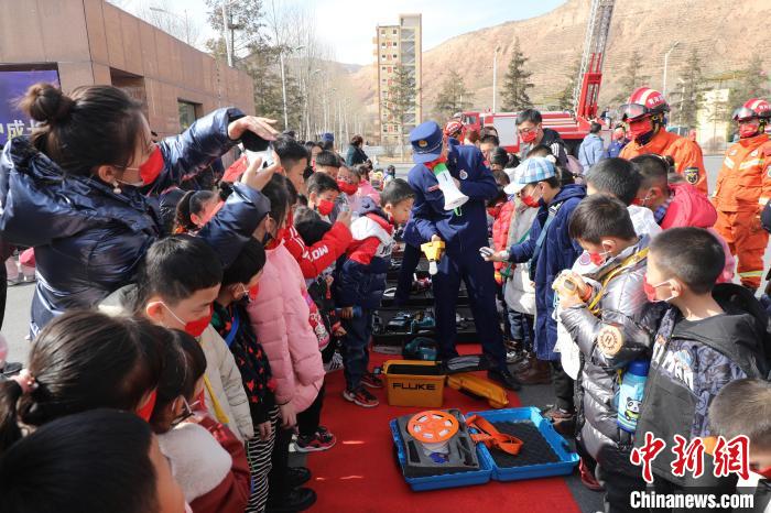圖為小朋友們聽(tīng)消防員講解消防器材?！铨埥?攝