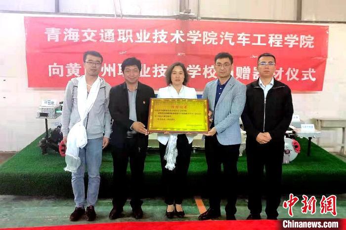 圖為李富香(中)代表學(xué)校為州縣技校捐贈(zèng)器材。(資料圖) 青海省教育廳供圖