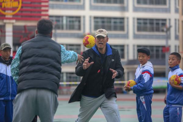 在高原上教孩子們打手球，“慢慢兒來(lái)，甭著急！”