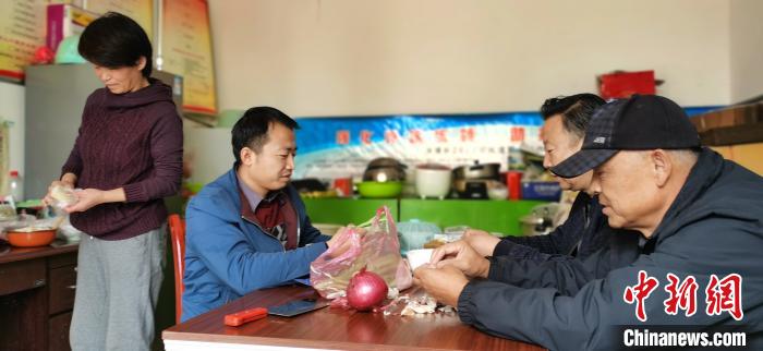圖為扶貧路上“臨時(shí)一家人”準(zhǔn)備午餐?！∥航ㄜ?攝