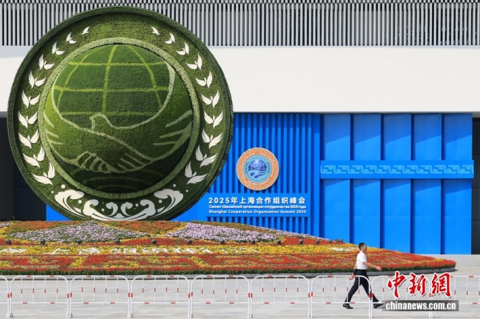 8月31日，天津，一名工作人員從2025年上海合作組織峰會(huì)主會(huì)場(chǎng)外的景觀花壇旁經(jīng)過。當(dāng)日，2025年上海合作組織峰會(huì)在天津舉行。<a target='_blank' href='/'><p  align=