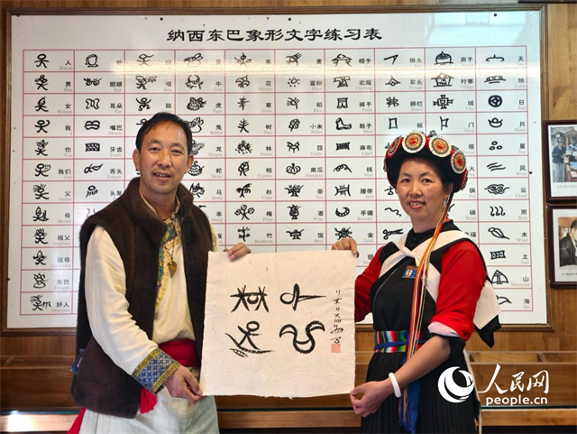 人民網(wǎng)“行進(jìn)中國(guó)”云南調(diào)研采訪團(tuán)走進(jìn)麗江，和閏元現(xiàn)場(chǎng)用東巴文寫(xiě)下“行進(jìn)中國(guó)”。人民網(wǎng)記者 符皓攝